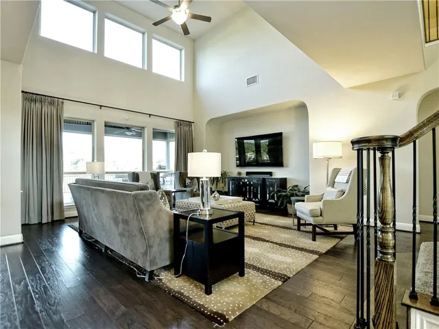 a living room with couches and a flat screen tv with kitchen view