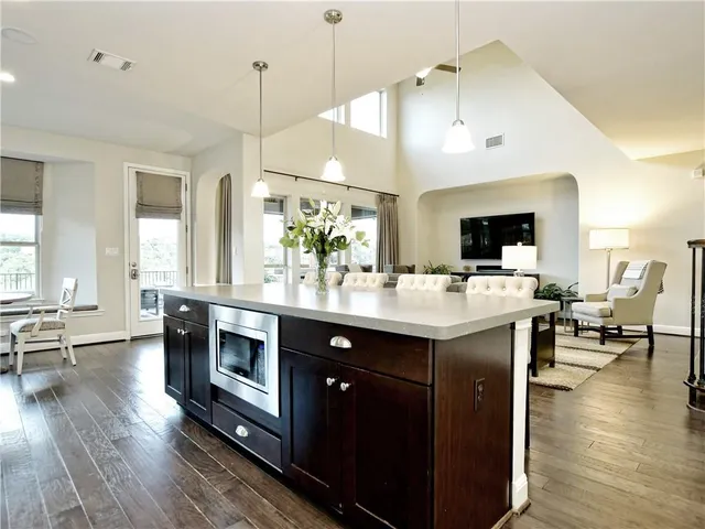 a kitchen with a sink appliances and wooden floor