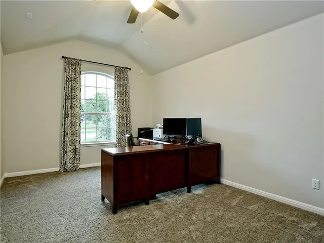 a view of a workspace with furniture and a window
