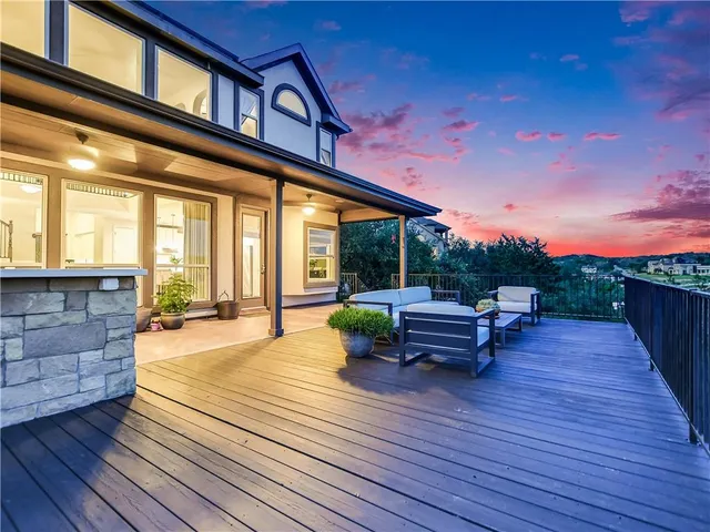 a view of a patio with dining table and chairs with wooden floor and fence