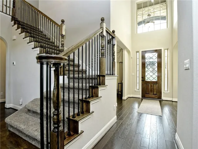 a view of a hallway with wooden floor and staircase