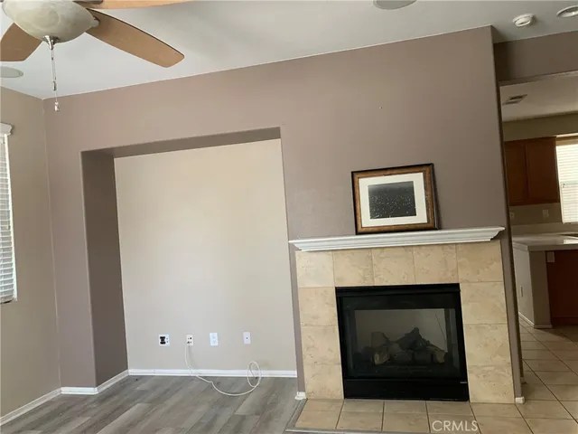 a living room with a fireplace and a ceiling fan
