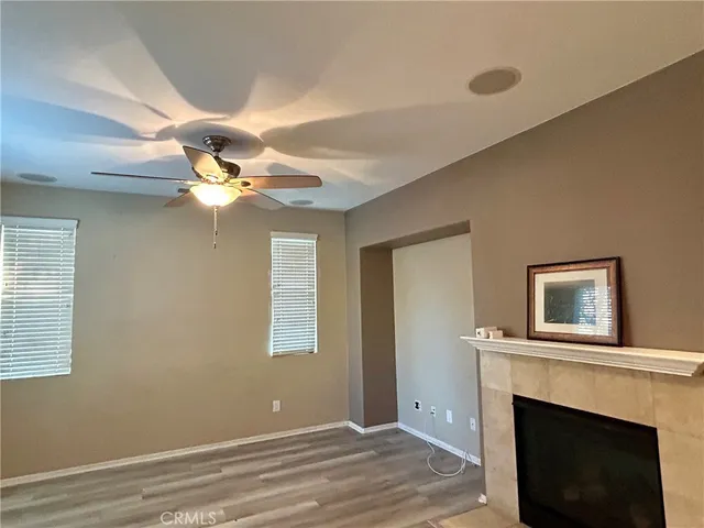 a view of a livingroom with a ceiling fan fireplace and a window