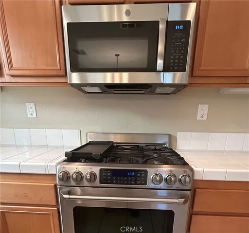 a stove top oven sitting inside of a kitchen