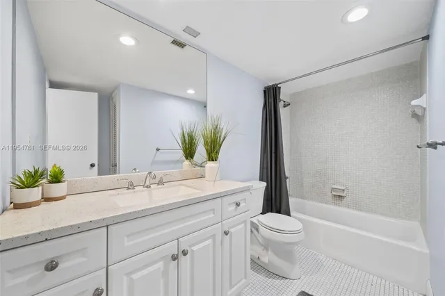 a bathroom with a double vanity sink toilet and shower