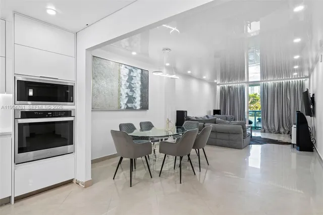 a dining hall with stainless steel appliances kitchen island granite countertop a stove and a sink