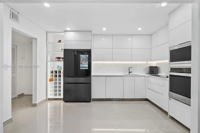 a kitchen with a refrigerator and a stove top oven