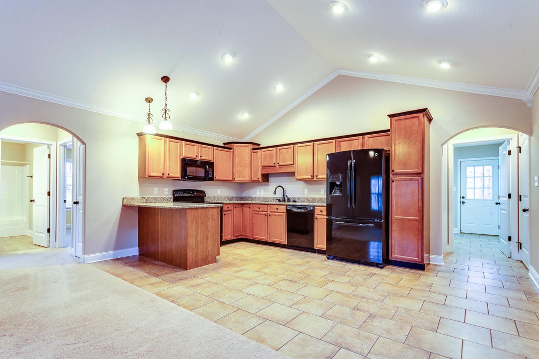 6067 Whisper Ridge Lane Corryton, TN 37721 - Photo 13 of 35 a large kitchen with stainless steel appliances kitchen island granite countertop a refrigerator and cabinets