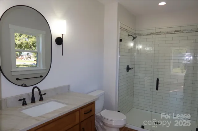 a bathroom with a sink toilet a mirror and shower