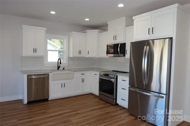 a kitchen with stainless steel appliances granite countertop a refrigerator sink and stove