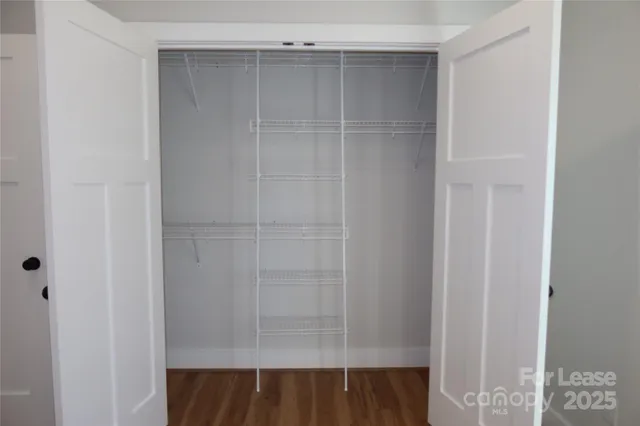 a view of walk in closet with empty racks