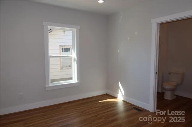 a view of room with a window and wooden floor