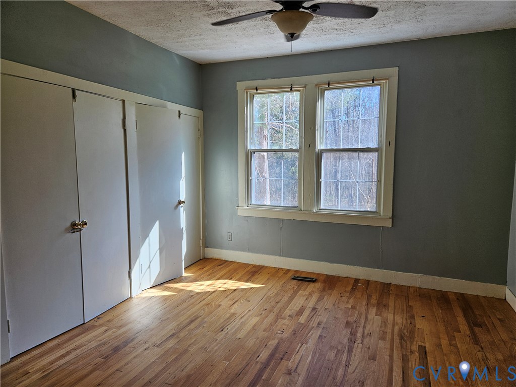 10030 Cheathams Road Amelia Court House, VA 23002 - Photo 11 of 23 a view of an empty room with wooden floor and a window