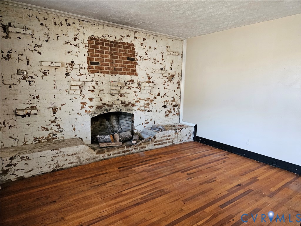 10030 Cheathams Road Amelia Court House, VA 23002 - Photo 6 of 23 a view of a livingroom with wooden floor and a fireplace