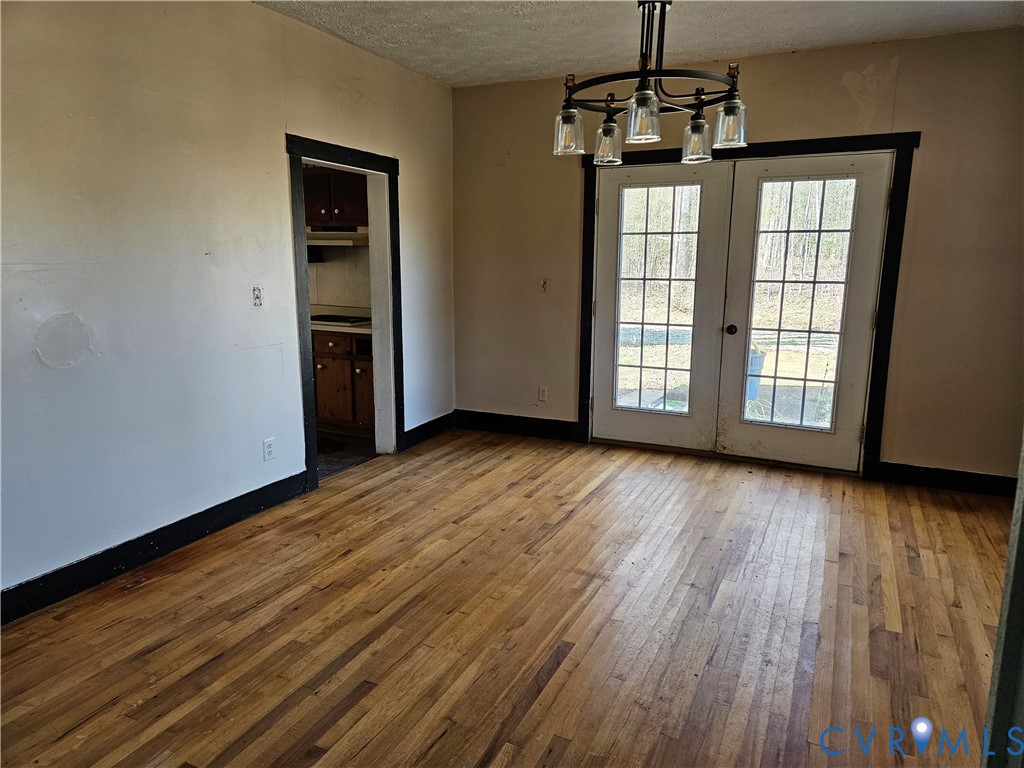 10030 Cheathams Road Amelia Court House, VA 23002 - Photo 7 of 23 an empty room with wooden floor staircase and windows