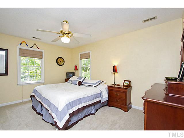 1117 Urania Drive Raleigh, NC 27603 - Photo 16 of 25 a bedroom with a bed and a chandelier