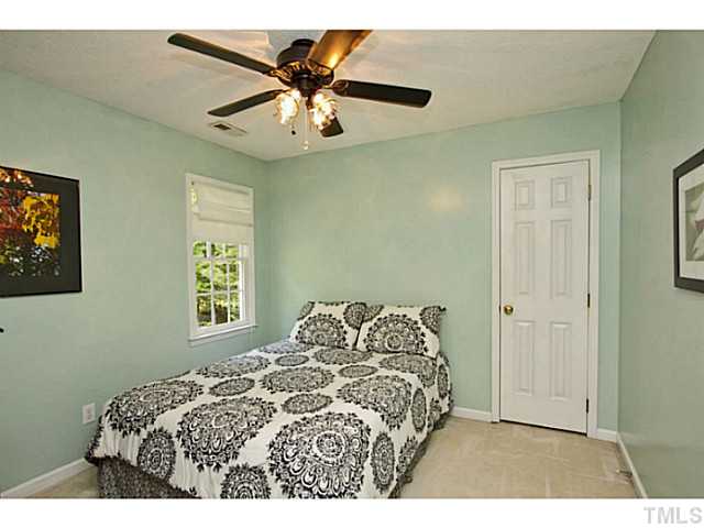 1117 Urania Drive Raleigh, NC 27603 - Photo 20 of 25 a bedroom with a bed and a chandelier