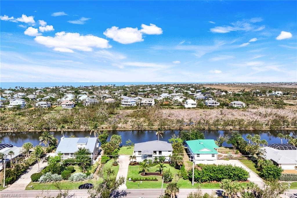 647 Rabbit Road Sanibel, FL 33957 - Photo 32 of 45 an aerial view of a city with lots of residential buildings and ocean view in back