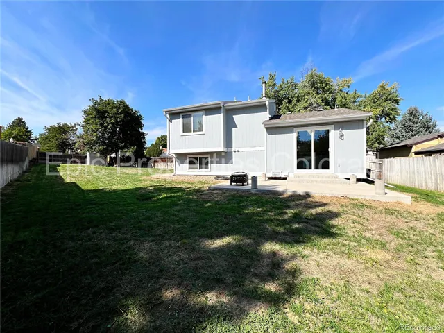 a view of a house with backyard and sitting area