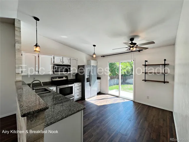 a kitchen with kitchen island granite countertop a stove a sink and a microwave