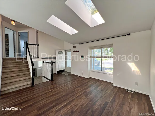 a hallway with wooden floor table and chairs
