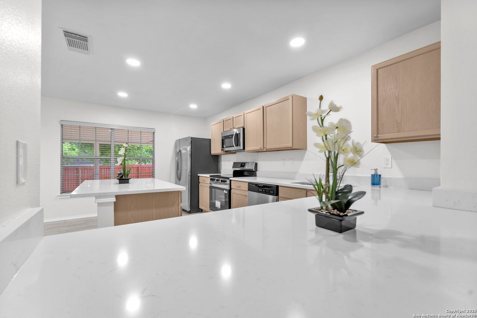 15515 Spring Summit San Antonio, TX 78247 - Photo 20 of 36 a kitchen with stainless steel appliances a dining table chairs and white cabinets
