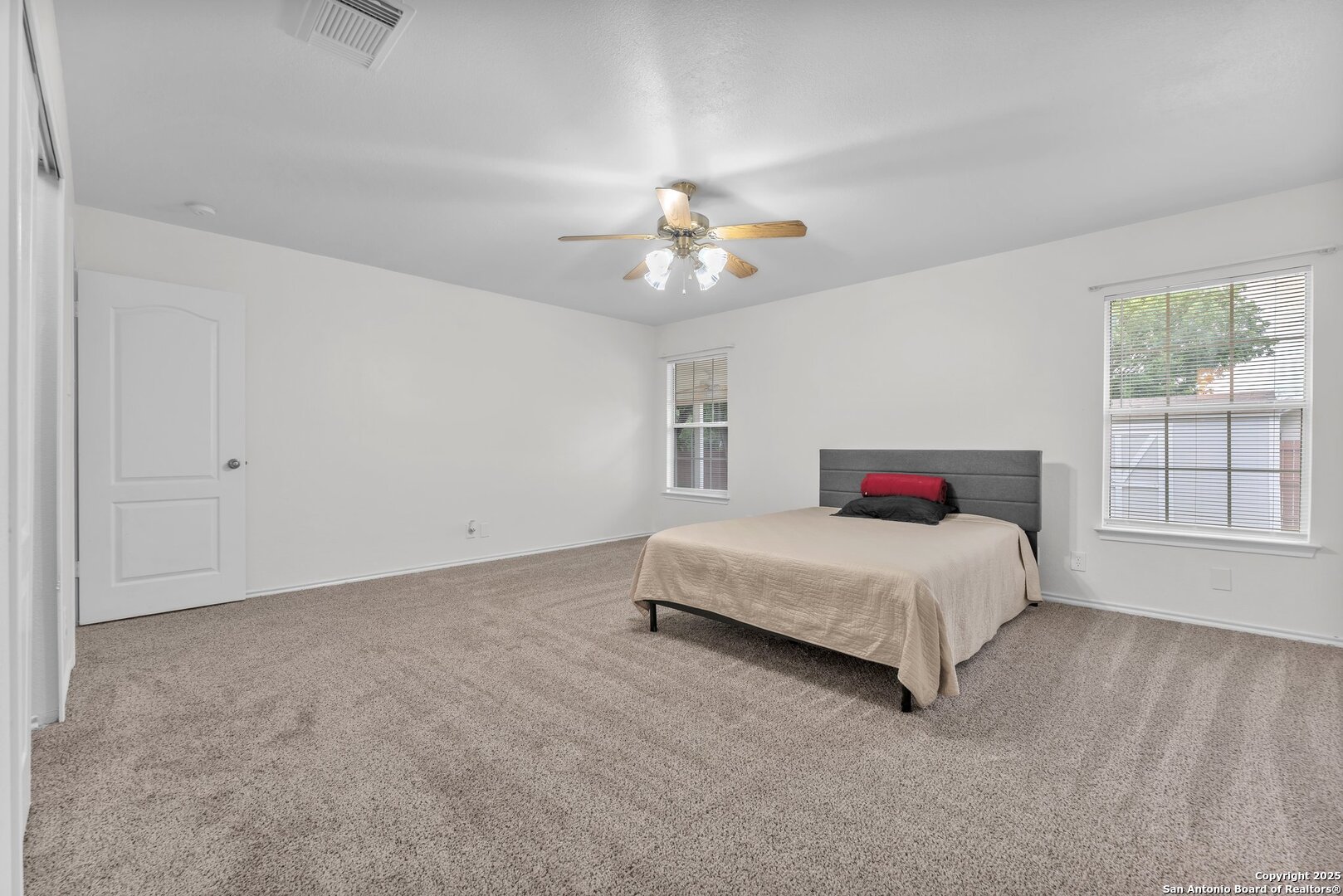 15515 Spring Summit San Antonio, TX 78247 - Photo 26 of 36 a spacious bedroom with a bed and a chandelier
