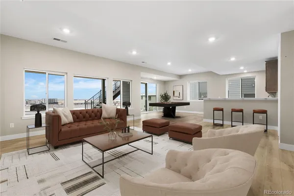 a living room with furniture and a view of kitchen