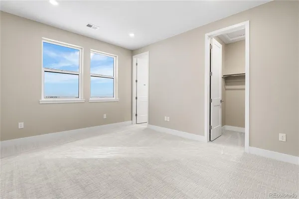 an empty room with windows and closet