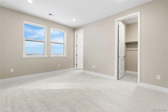 an empty room with windows and closet