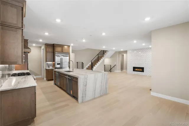 a large kitchen with stainless steel appliances a large counter top a stove and a sink