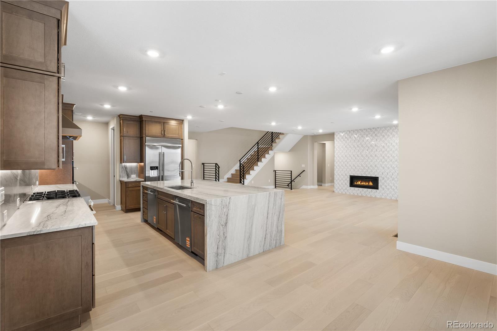 11293 Tenor Trail Lone Tree, CO 80134 - Photo 3 of 50 a large kitchen with stainless steel appliances a large counter top a stove and a sink