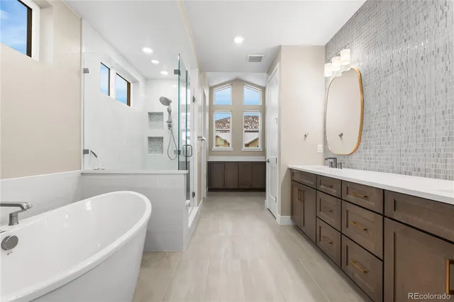 a spacious bathroom with a tub sink and mirror