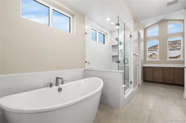 a bathroom with a tub a sink and mirror