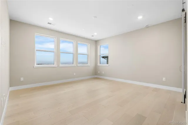 an empty room with windows and closet