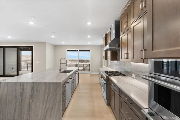 a kitchen with stainless steel appliances granite countertop a stove a sink and a refrigerator