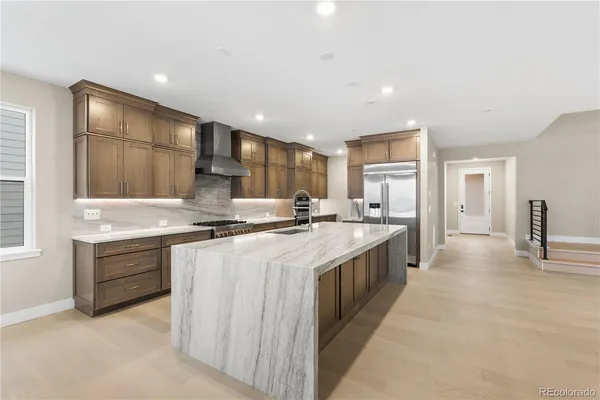 a large kitchen with stainless steel appliances granite countertop a lot of counter space and wooden floors