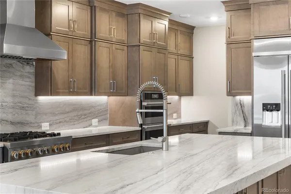 a kitchen with stainless steel appliances granite countertop a refrigerator and a stove