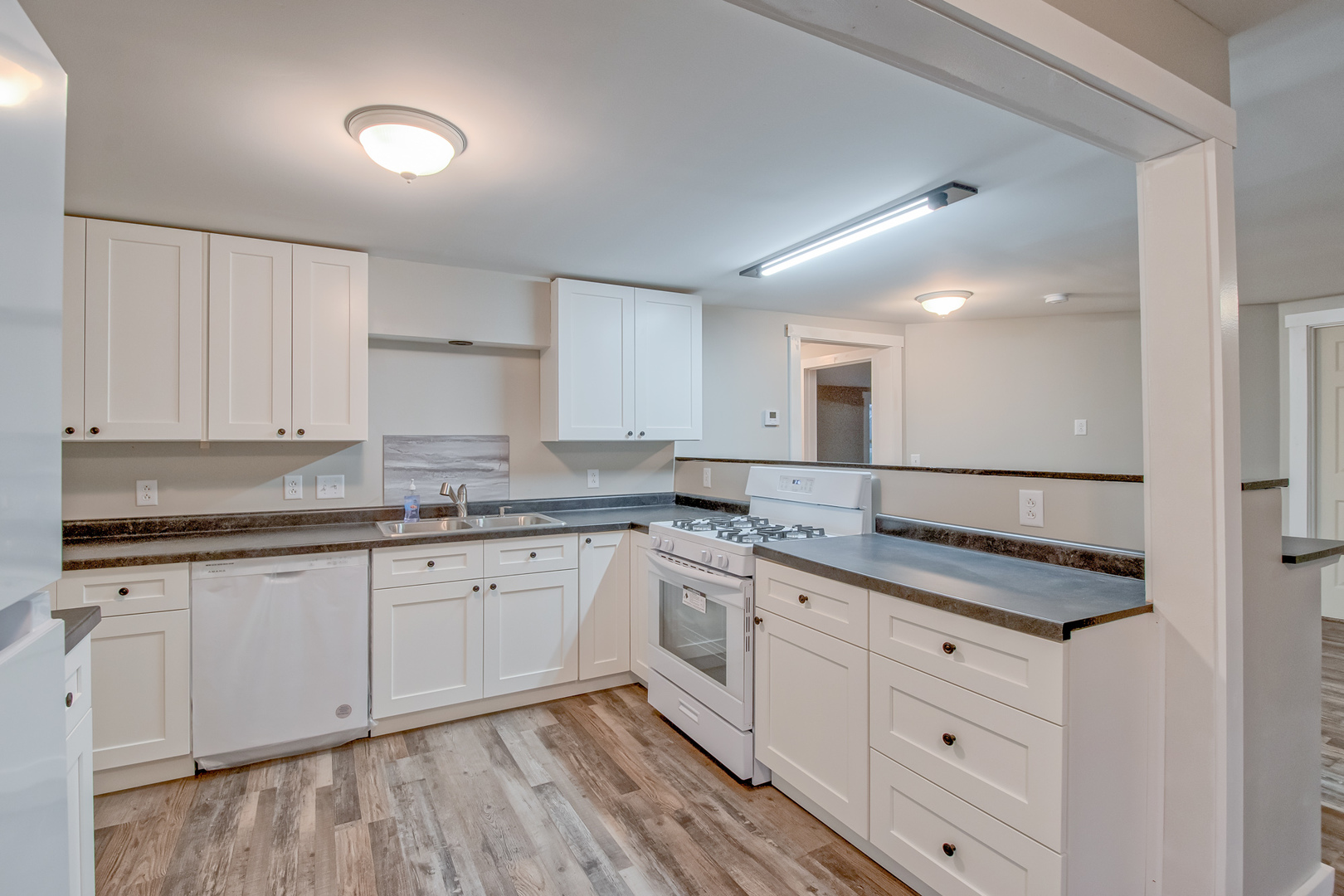 26769 North Genesee Street Wauconda, IL 60084 - Photo 7 of 16 a kitchen with granite countertop white cabinets and white appliances