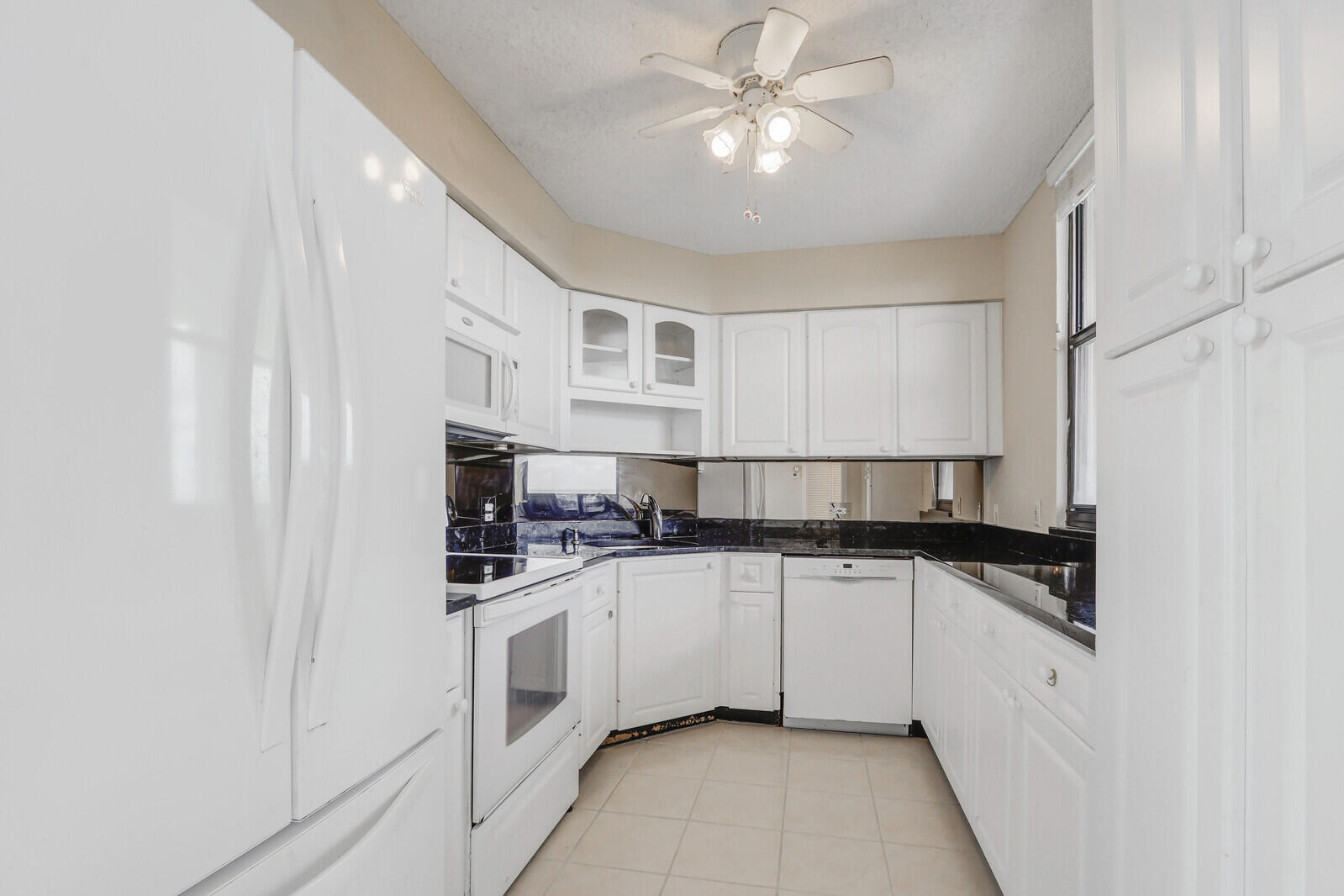 132 Lakeshore Drive, Unit 1117 North Palm Beach, FL 33408 - Photo 11 of 35 a kitchen with stainless steel appliances a sink a stove a microwave and cabinets