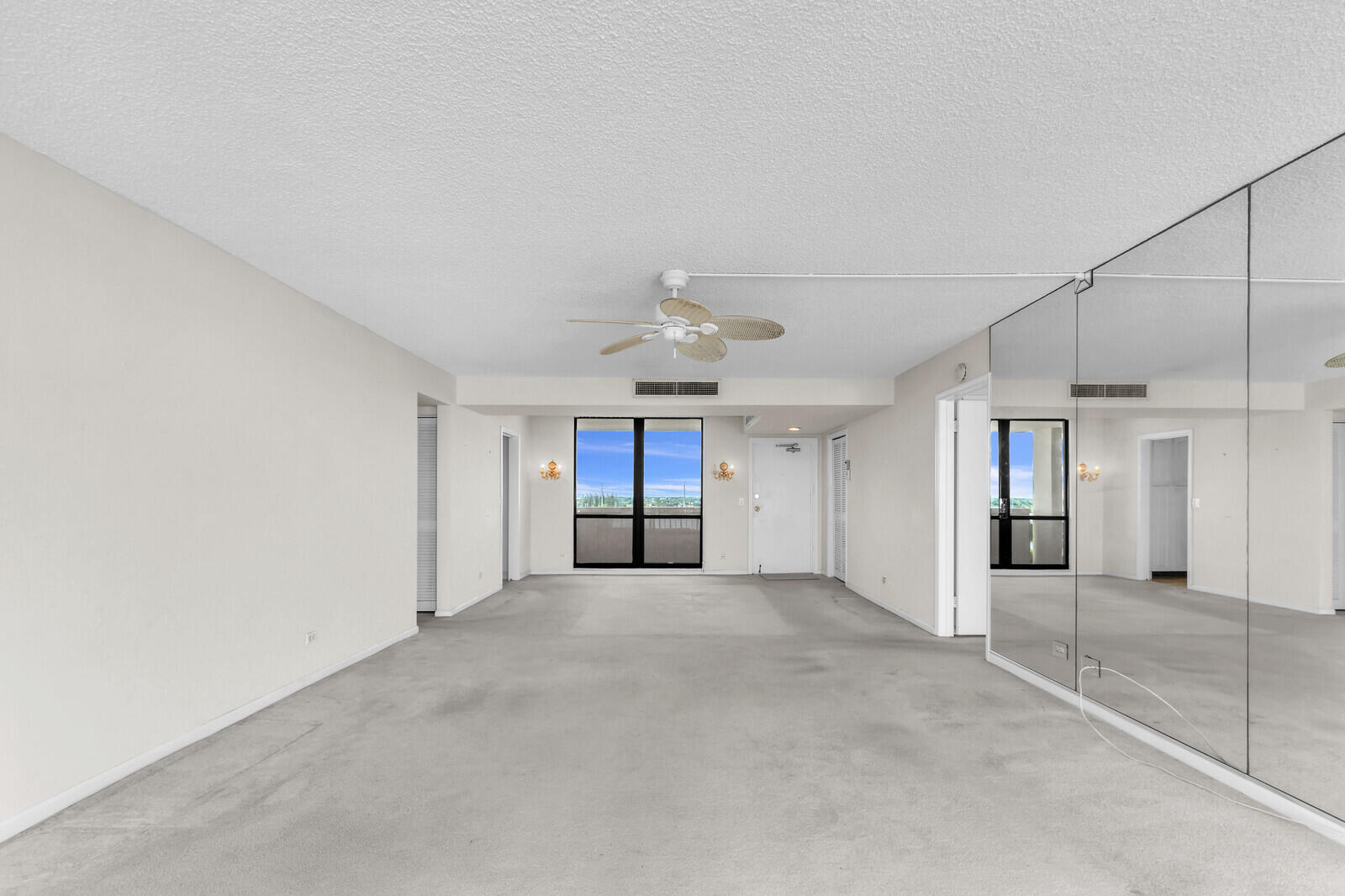 132 Lakeshore Drive, Unit 1117 North Palm Beach, FL 33408 - Photo 9 of 35 an empty room with windows and a ceiling fan