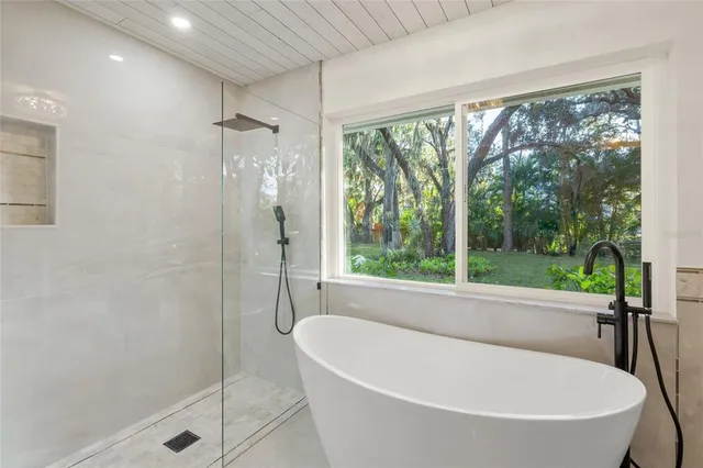a white bath tub sitting in front of a shower