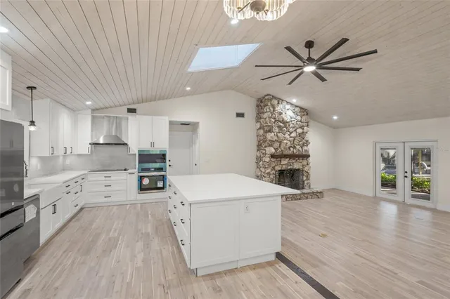 a large white kitchen with a stove a sink dishwasher and a refrigerator