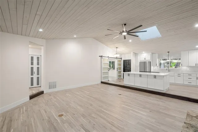 wooden floor in an empty room with a kitchen