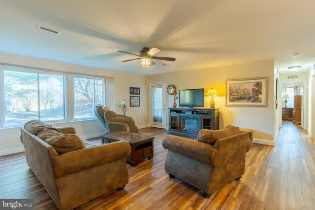 a living room with furniture and a flat screen tv with wooden floor