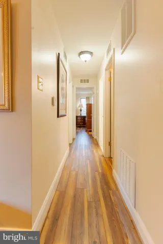 a view of a hallway with wooden floor