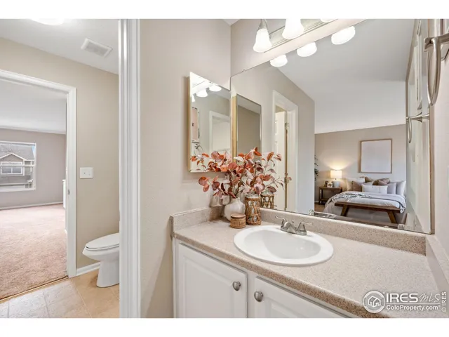 a bathroom with a granite countertop sink a toilet and a mirror