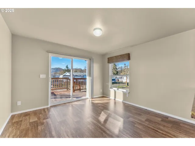 view of an empty room with wooden floor and a window