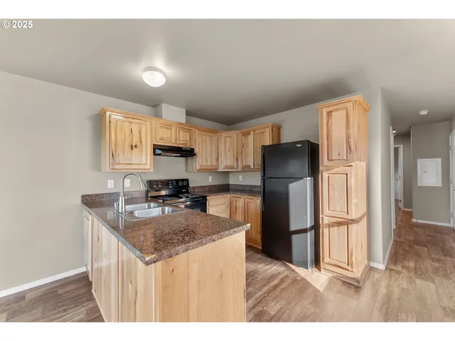 a kitchen with granite countertop a refrigerator and a sink