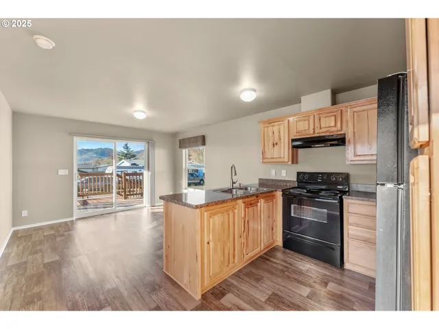 a kitchen with stainless steel appliances granite countertop a stove a sink dishwasher and a refrigerator